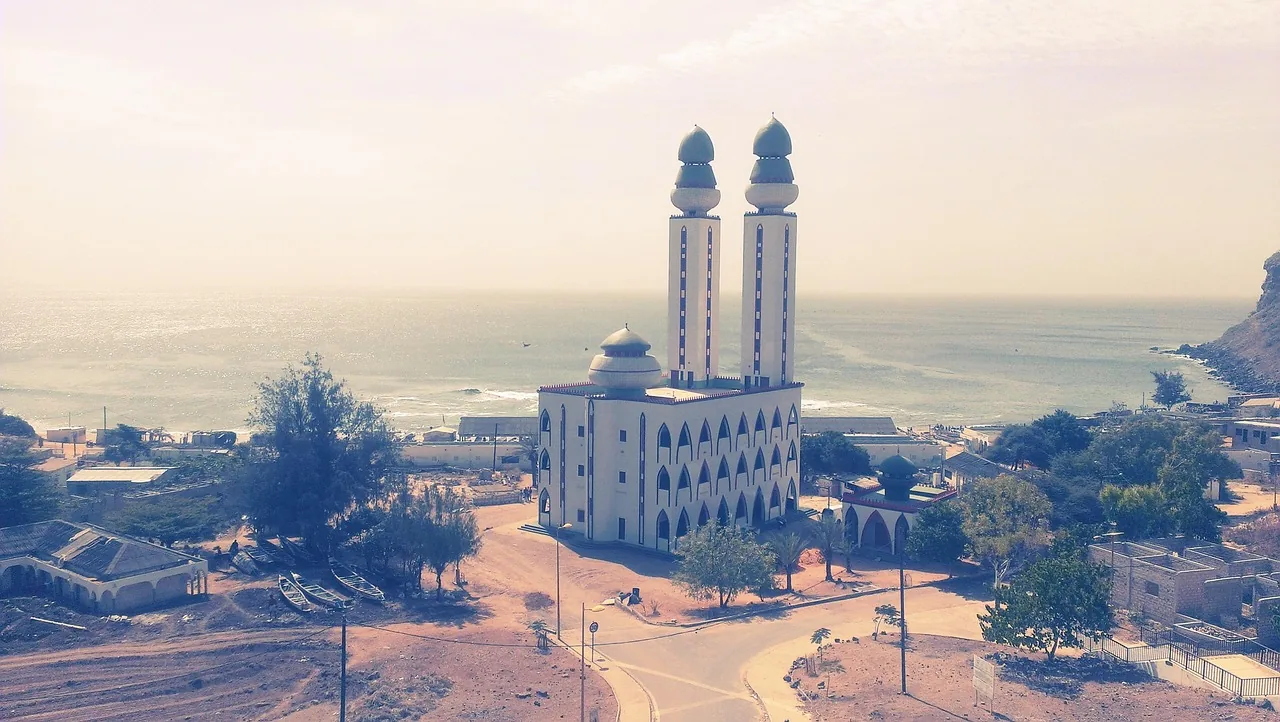 Mosquée blanche aux deux minarets bleus dominant le paysage côtier de Dakar