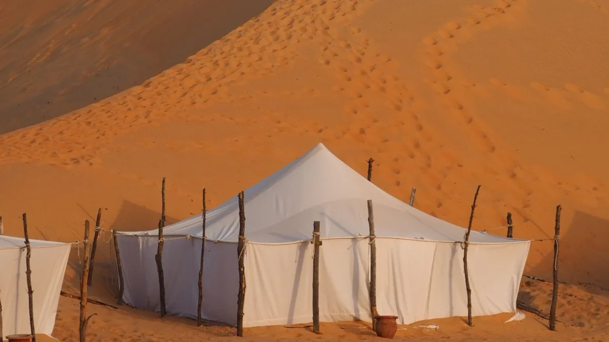 Tentes blanches d'un campement au pied des dunes orangées du désert de Lompoul, au Sénégal